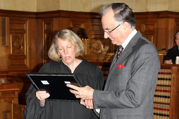 Chief Justice Chase T. Rogers reads the award citation to Connecticut Supreme Court Historical Society President Wesley W. Horton.