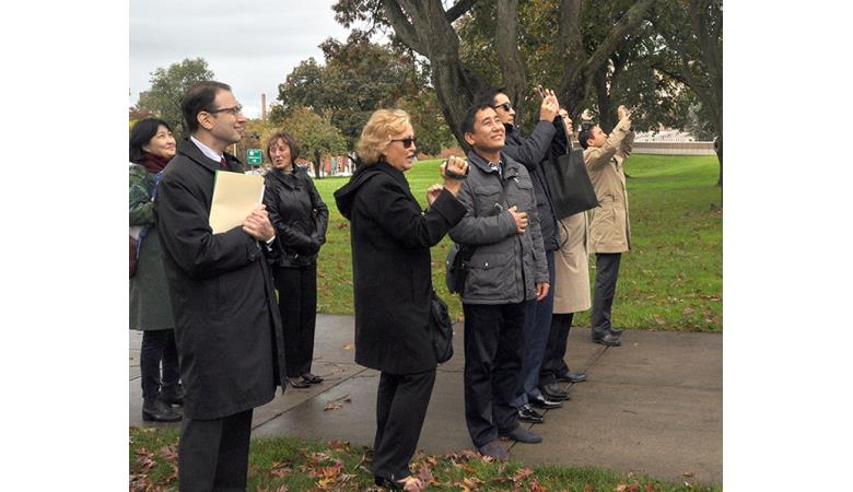 Members of the Kyrgyz Republic delegation watch as their flag is hoisted above the State Capitol on Friday, Oct. 24, 2014.  